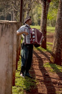 Açık havada mızıka çalan tipik kostümlü Gaucho çocuğu..