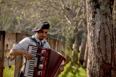 Açık havada mızıka çalan tipik kostümlü Gaucho çocuğu..