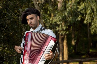 Açık havada mızıka çalan tipik kostümlü Gaucho çocuğu..