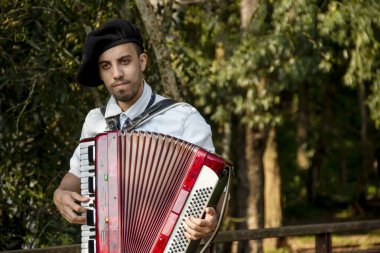 Açık havada mızıka çalan tipik kostümlü Gaucho çocuğu..