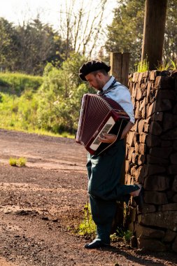 Gaucho ayakta mızıka çalıyor..