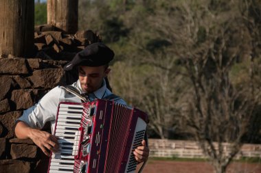 Açık havada mızıka çalan tipik kostümlü Gaucho çocuğu..