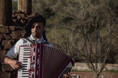 Açık havada mızıka çalan tipik kostümlü Gaucho çocuğu..