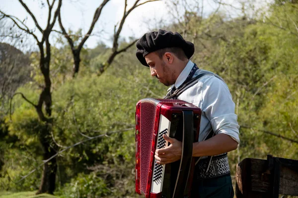 Açık havada mızıka çalan tipik kostümlü Gaucho çocuğu..