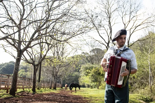 Gaucho ayakta mızıka çalıyor..