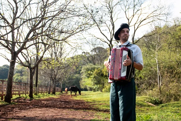 Gaucho ayakta mızıka çalıyor..