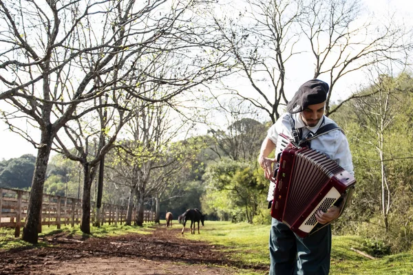Gaucho ayakta mızıka çalıyor..