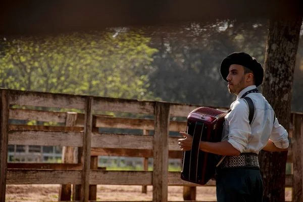 Açık havada mızıka çalan tipik kostümlü Gaucho çocuğu..