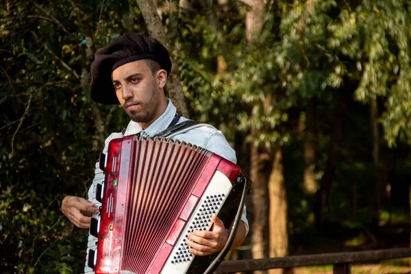 Açık havada mızıka çalan tipik kostümlü Gaucho çocuğu..