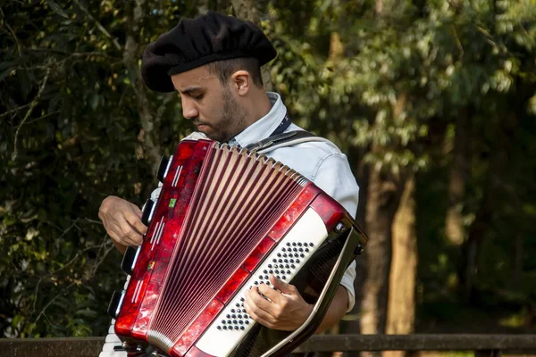 Açık havada mızıka çalan tipik kostümlü Gaucho çocuğu..