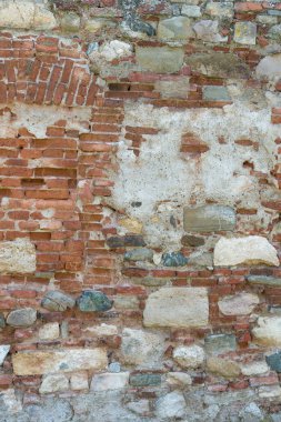 Gri tonlarında kalın harç ve çok sert, düzensiz yüzey ile eski tuğla ve taş duvar.