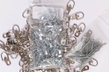 Metal plakalar, kanca ve tırnak üzerinde beyaz izole asılı çerçeve grupları.