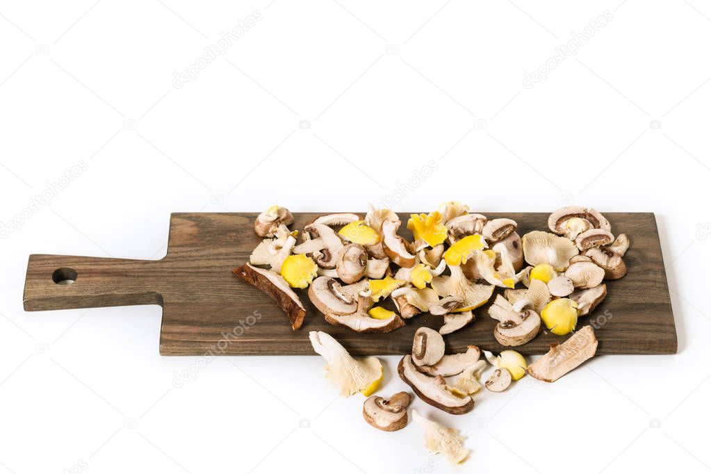 Variety of mixed exotic mushrooms on a cutting board.