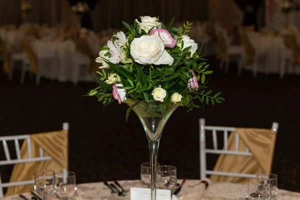 Floral centerpiece at luxury, elegant wedding reception table arrangement in banquet hall.