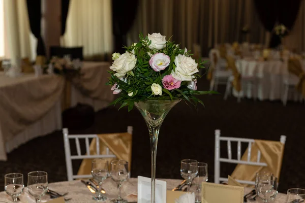 Floral centerpiece at luxury, elegant wedding reception table arrangement in banquet hall.