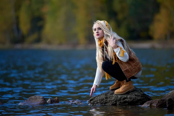 年轻漂亮的女人坐在湖边的秋季户外 — 图库照片