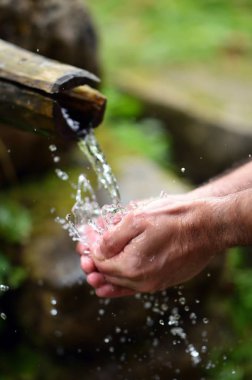 Adam dağ baharın taze, soğuk, içilebilir su el yıkama