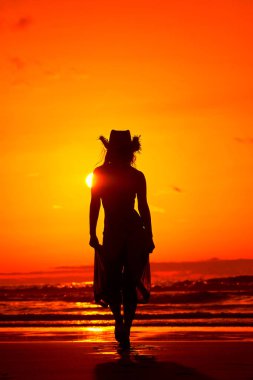 genç bir kadın silueti sahilde günbatımı yaz ışık