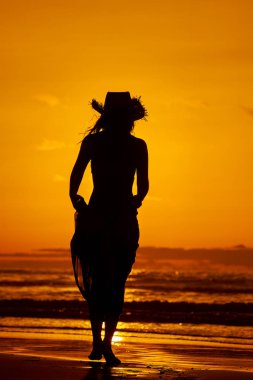 genç bir kadın silueti sahilde günbatımı yaz ışık