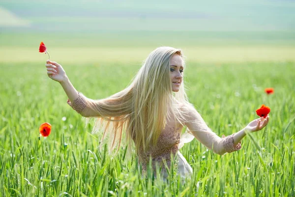 在绿色的田野 罂粟花在弹簧上的漂亮女孩 — 图库照片