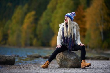 genç güzel kadın açık göl kenarında oturan Güz