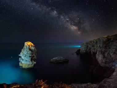 çarpıcı Canlı Samanyolu görüntünün üzerinde kayalık uçurum ve deniz, gece manzarası 