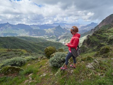 Manzara, Gran Canaria, İspanya hayran Cliff'in kenarında oturan genç kadın turist