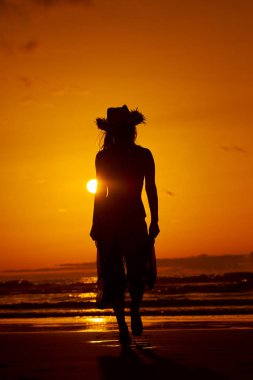 genç bir kadın silueti sahilde günbatımı yaz ışık