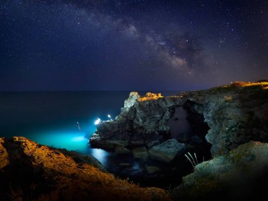 çarpıcı Canlı Samanyolu görüntünün üzerinde kayalık uçurum ve deniz, gece manzarası 