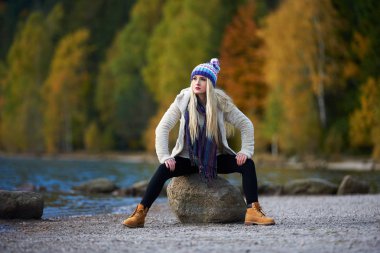 genç güzel kadın açık göl kenarında oturan Güz