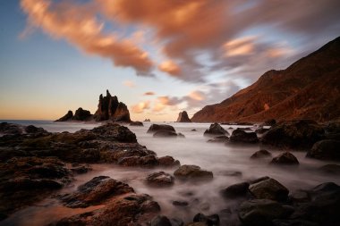 view of wild Benijo beach with big waves and black sand on the north coast of the Tenerife island, Spain - long exposure image clipart