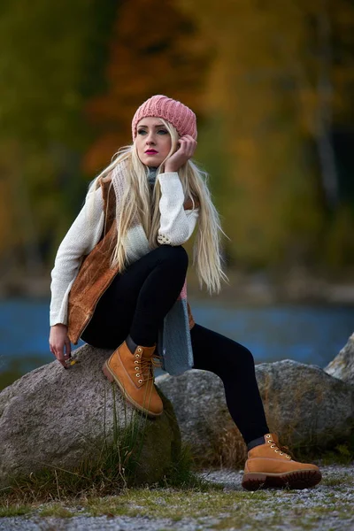 湖のほとりに座っている秋に屋外若いきれいな女性 — ストック写真