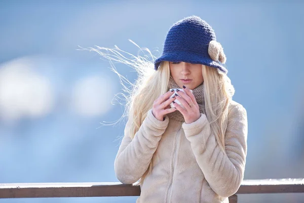 年轻漂亮的女人在户外在冬天拿着杯子在她的手 — 图库照片