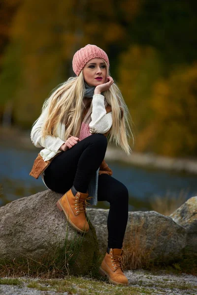 年轻漂亮的女人坐在湖边的秋季户外 — 图库照片