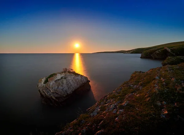 seascape by night in summer with moon reflection on the water surface