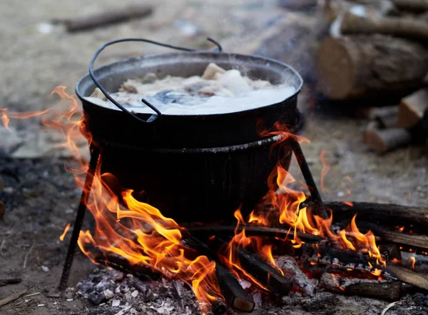 preparing food on camp - hot food boiling in the big pot over the fire