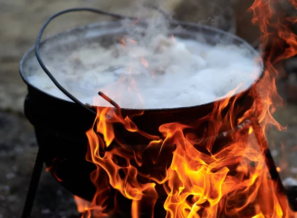 preparing food on camp - hot food boiling in the big pot over the fire