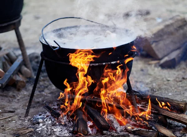 preparing food on camp - hot food boiling in the big pot over the fire