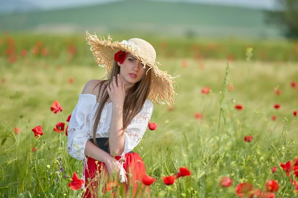 夏の晴れた日のポピーと穀物のフィールド上で若い美しい女性 — ストック写真