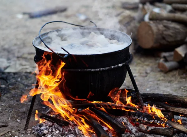 preparing food on camp - hot food boiling in the big pot over the fire