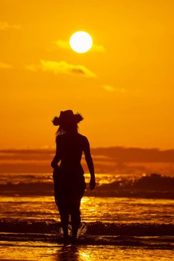 genç bir kadın silueti sahilde günbatımı yaz ışık