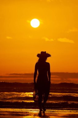 genç bir kadın silueti sahilde günbatımı yaz ışık