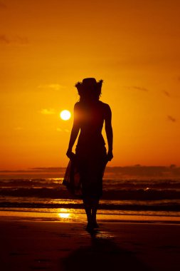 genç bir kadın silueti sahilde günbatımı yaz ışık