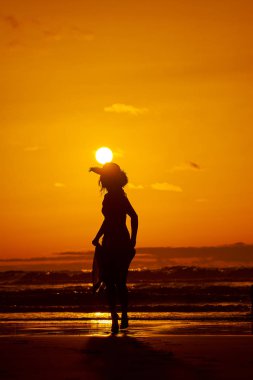 genç bir kadın silueti sahilde günbatımı yaz ışık