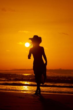 genç bir kadın silueti sahilde günbatımı yaz ışık