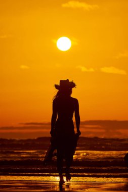 genç bir kadın silueti sahilde günbatımı yaz ışık