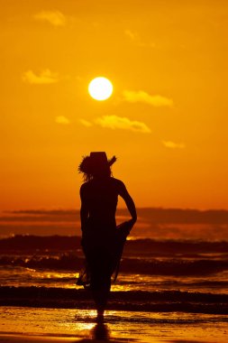 genç bir kadın silueti sahilde günbatımı yaz ışık