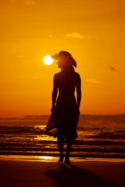 genç bir kadın silueti sahilde günbatımı yaz ışık