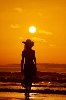 genç bir kadın silueti sahilde günbatımı yaz ışık
