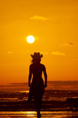 genç bir kadın silueti sahilde günbatımı yaz ışık